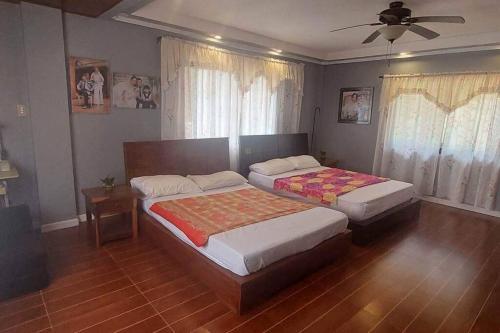 a bedroom with two beds and a ceiling fan at Malbros guest house in Baguio