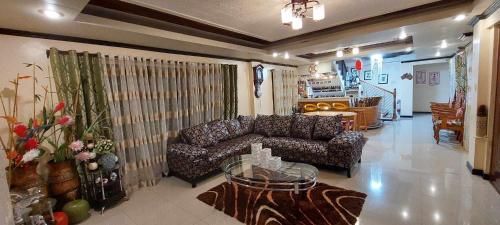 sala de estar con sofá y mesa en Malbros guest house en Baguio
