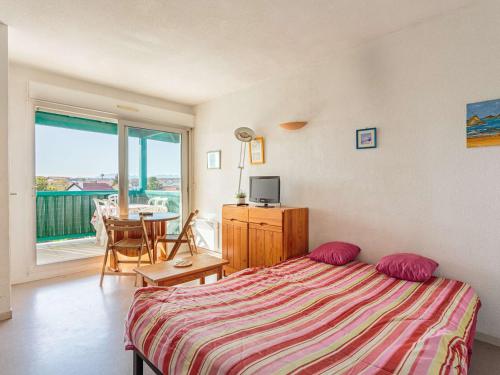 Schlafzimmer mit einem Bett und einem Tisch sowie einem Balkon in der Unterkunft Appartement Anglet, 2 pièces, 4 personnes - FR-1-3-592 in Anglet