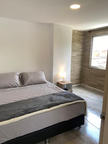 a bedroom with a large bed and a window at Apartamento con Excelente Ubicación en Envigado in Envigado