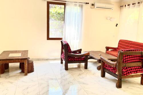 a living room with a wooden table and chairs at Romantic Mediterranean beach house in Dar es Salaam