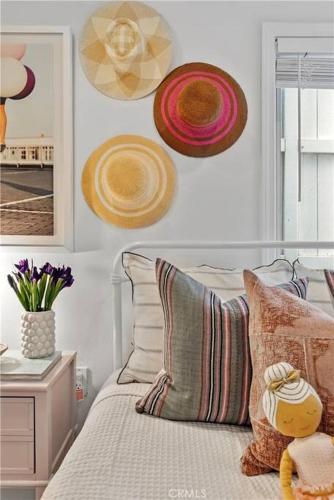 a bedroom with a bed with hats on the wall at Amazing location! Luxurious beach cottage.Ocean views in Manhattan Beach