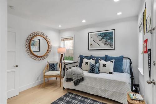 a bedroom with a bed with blue pillows and a mirror at Amazing location! Luxurious beach cottage.Ocean views in Manhattan Beach