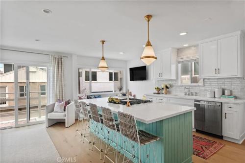 a kitchen with a large island with bar stools at Amazing location! Luxurious beach cottage.Ocean views in Manhattan Beach