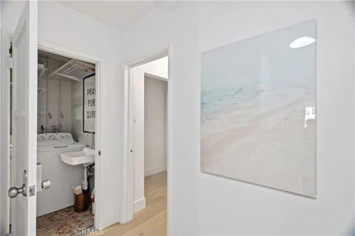 a bathroom with a sink and a picture of the ocean at Amazing location! Luxurious beach cottage.Ocean views in Manhattan Beach