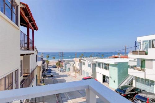a view of the beach from the balcony of a building at Amazing location! Luxurious beach cottage.Ocean views in Manhattan Beach