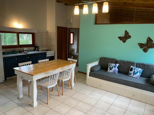 a kitchen and living room with a table and a couch at Kimbara Bosque y Mar in Mar de las Pampas