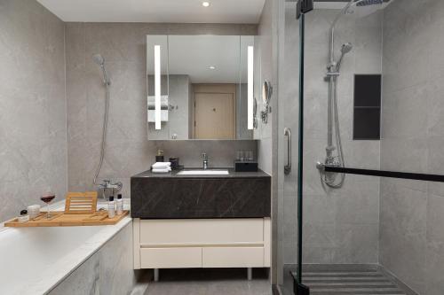 a bathroom with a sink and a shower at Somerset Taihu New City CBD Wuxi in Wuxi
