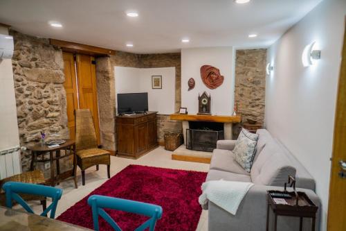 a living room with a couch and a fireplace at Casa da Rua histórica, Cabeceiras de Basto T3 in Cabeceiras de Basto