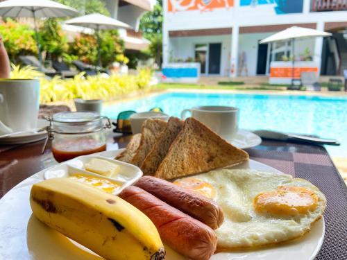 a plate of breakfast food with eggs sausage and toast at Amihan Resort in Panglao
