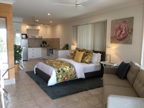 a large bedroom with a bed and a couch at SilverWaters Waterfront Accommodation Lake Macquarie in Morisset East