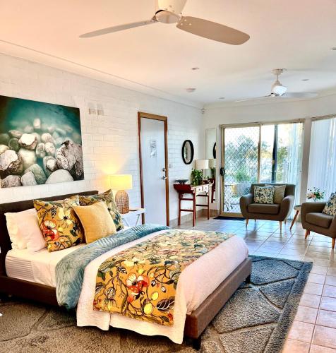 a bedroom with a large bed with a painting on the wall at SilverWaters Waterfront Accommodation Lake Macquarie in Morisset East