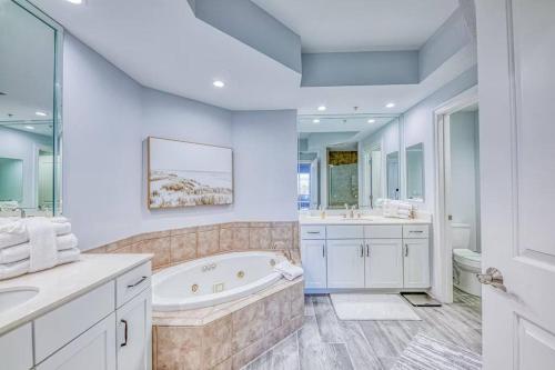 a white bathroom with a tub and a sink at Foxy Palmer! 3 bedroom 2 bath in Perdido Golf Resort in Pensacola