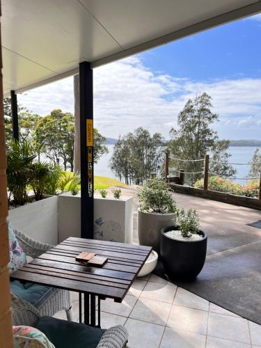 a patio with a table and a view of the water at SilverWaters Waterfront Accommodation in Morisset East