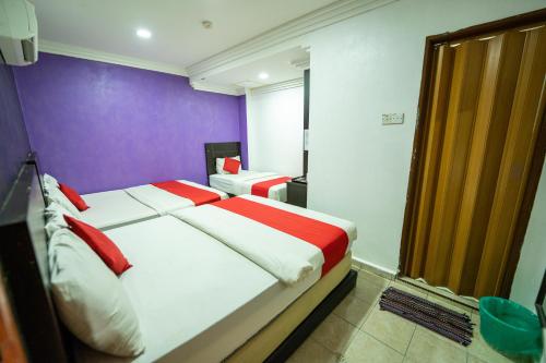 a bedroom with a bed with red and white sheets at MRJ Hotel Wakaf Che Yeh 2 in Kota Bharu