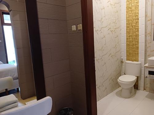 a bathroom with a toilet and a shower at Alsalam Syariah Guesthouse in Solo