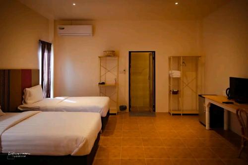 um quarto de hotel com duas camas e uma televisão em กมุทมาศ สวรรคโลก em Ban Pa Muang (1)