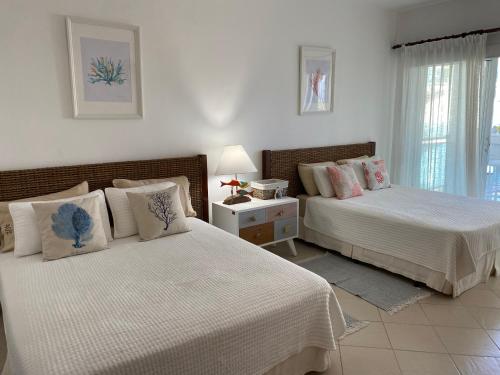 um quarto com 2 camas e uma mesa com um candeeiro em Palmeraie Terrenas beach apartamento em Las Terrenas