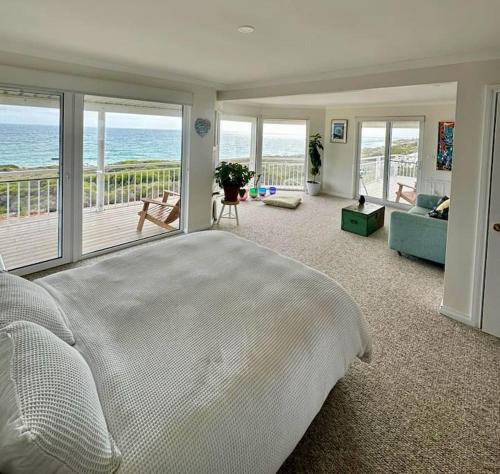a bedroom with a bed and a view of the ocean at Arcadia Beachfront Retreat in Mandurah