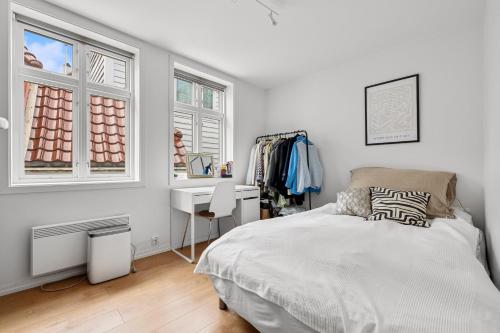 una camera con letto, scrivania e finestre di Behind Bryggen - Renovated - Budget friendly a Bergen