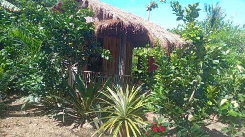uma pequena cabana com um telhado de palha num jardim em Battambang Eco Stay em Phumĭ Ândong Pring