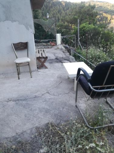um par de cadeiras e uma mesa num pátio em Orman ev em Ayvacık
