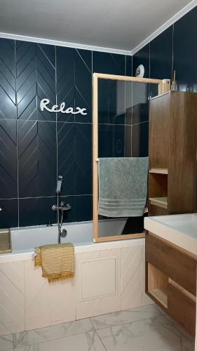 La salle de bains est pourvue d'un mur carrelé bleu et d'un lavabo. dans l'établissement Luxueux appartement centre, à Antibes