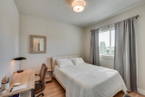 a bedroom with a bed and a desk and a window at Bright Central Point Home with Deck and Mountain Views in Central Point