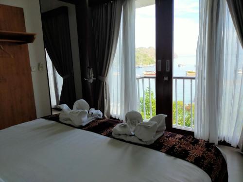 Una habitación de hotel con una cama con toallas. en Escape Bajo en Labuan Bajo