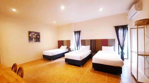 a hotel room with two beds in a room at กมุทมาศ สวรรคโลก in Ban Pa Muang (1)