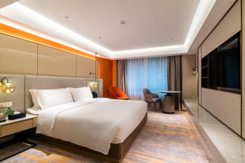 a hotel room with a large bed and a television at Landmark International Hotel in Guangzhou