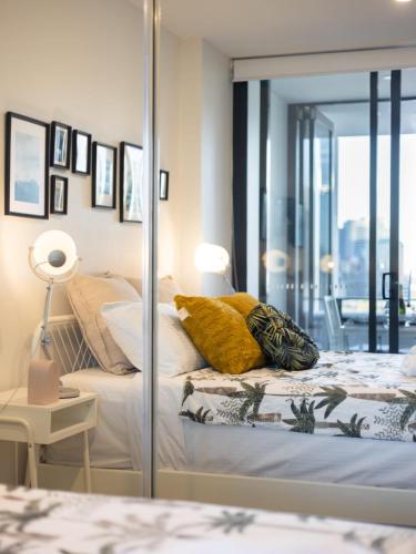 a bedroom with a bed with a glass wall at Explore BNE from our Cute 1-Bed Apartment in South Brisbane in Brisbane