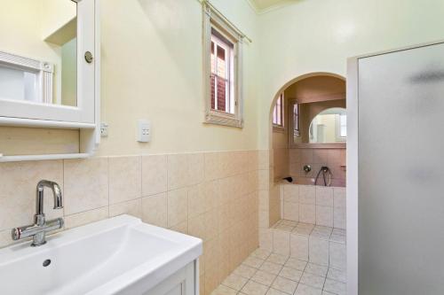 a bathroom with a sink and a shower at Belle Escapes - Glenelg Cottage by the Marina in Glenelg