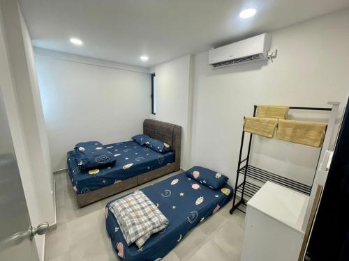 a small room with two beds and a heater at Sandakan Homestay Coastal Serenity 山海绿栖 in Sandakan
