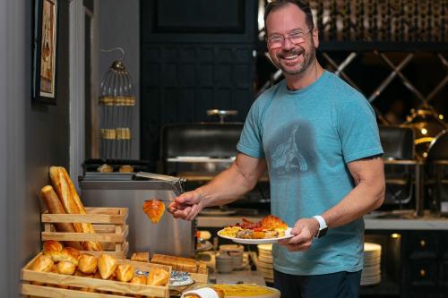 a man is holding a plate of food at Scent Premium Hotel in Hanoi