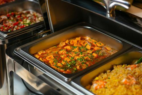 a tray of food in an oven with food at Scent Premium Hotel in Hanoi