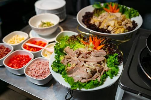 a table with plates of food and bowls of ingredients at Scent Premium Hotel in Hanoi