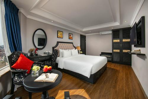 a hotel room with a bed and a desk and a mirror at Scent Premium Hotel in Hanoi