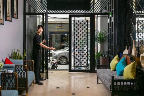 a man standing outside of a glass door at Scent Premium Hotel in Hanoi