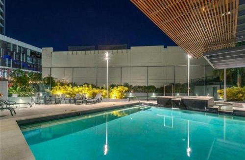a swimming pool in front of a building at night at AAB Apartments Skyline in Brisbane