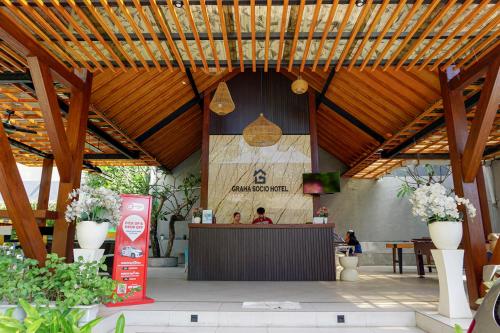 a restaurant with a bar in the middle of a building at Graha Socio Hotel Nusa Dua Bali in Nusa Dua