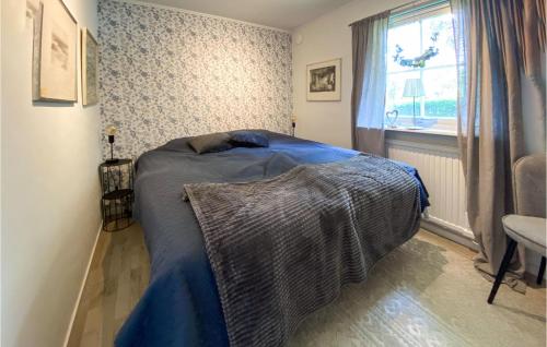 1 dormitorio con 1 cama con edredón azul y ventana en Stunning Home In Glommen With House Sea View, en Glommen