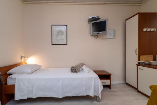 a bedroom with a bed and a tv on the wall at Villa Bakica in Trogir