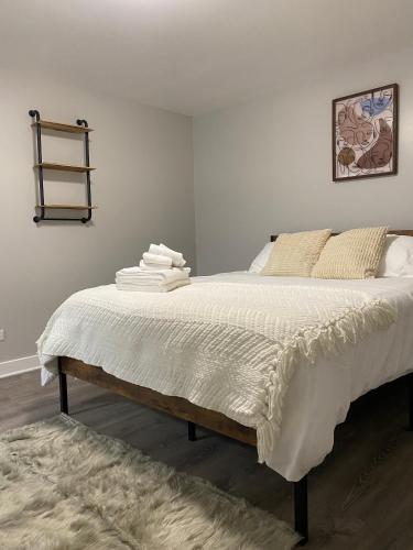a bedroom with a bed with white sheets and a rug at Stylish Urban Retreat 3 Bedroom Newly Remodeled in Chicago