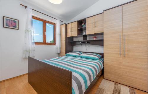 een slaapkamer met een bed en houten kasten bij Gorgeous Home In Slivnica With Kitchen in Slivnica