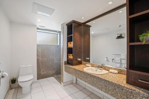 a bathroom with a sink and a toilet and a mirror at Lakeside Living - 1 Bedroom Alpine Apartment 1 in Queenstown