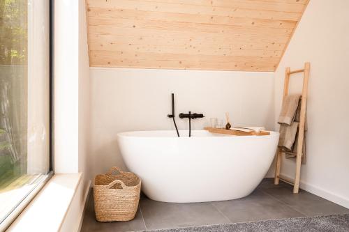 扎沃亚Babia Rest - całoroczny domek z balią z jacuzzi的带窗户的浴室里的白色浴缸