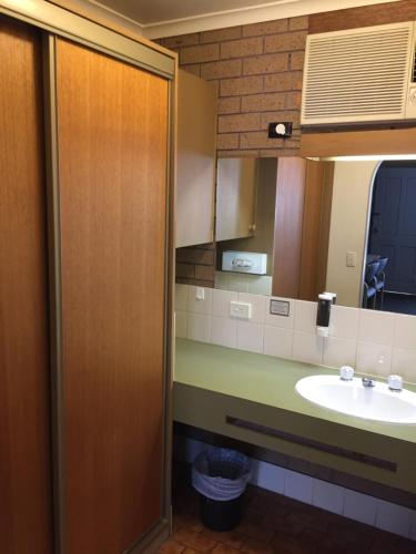 a bathroom with a sink and a mirror at Eaglehawk Motel Bendigo in Bendigo