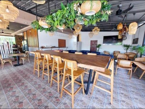 a large wooden table and chairs in a room at Guesthouse and Restaurant Ratatouille in Baan Tai