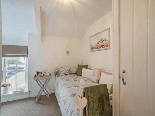 a small bedroom with a bed and a table at Melie-rose in Aberdare